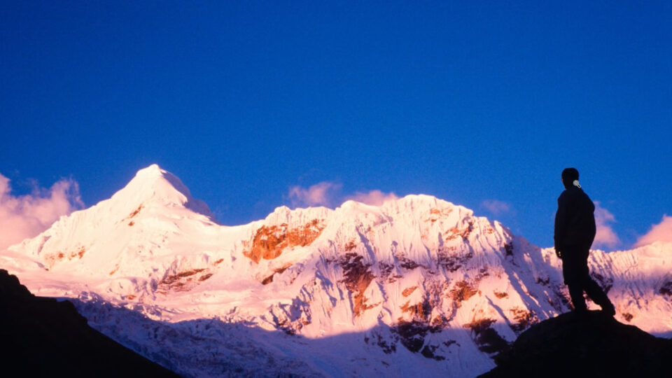 Vintage film photo of a person silhouetted against an alpenglow mountain range restored using Restore AI in ON1 Photo RAW MAX 2026.4, demonstrating detail recovery and color restoration on aging images