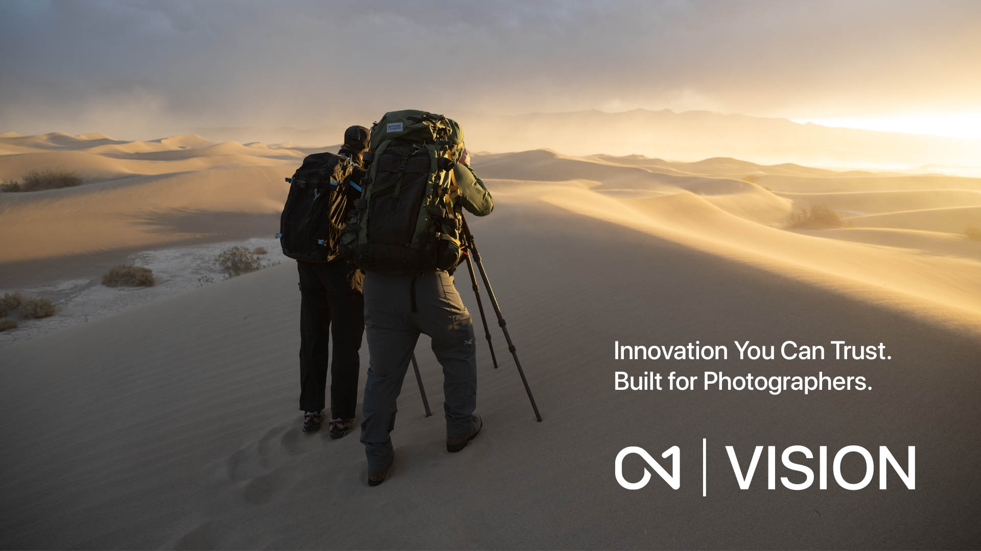 Two photographers photographing sand dunes at sunrise, representing ON1’s vision of trusted innovation built for photographers.