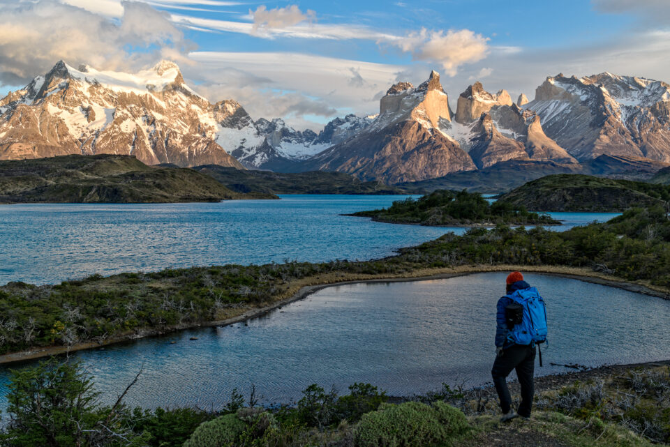 A hiker overlooking a calm mountain landscape and lake, representing thoughtful progress and areas of focus for improvement.